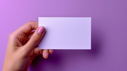 Obraz premium hand holding a card on a purple background