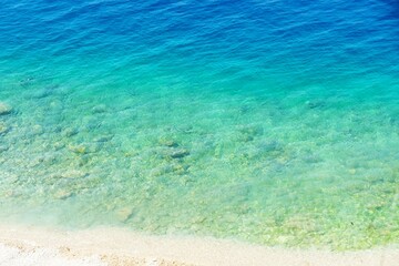 Turquise clear blue sea with sandy beach summer background