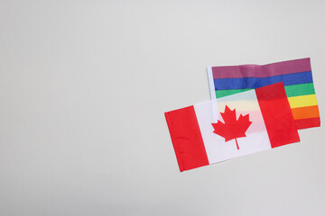 Canada flag with rainbow flag on light background