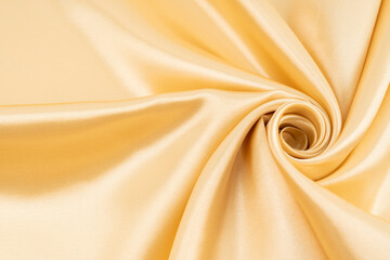 Selective focus abstract image of gold color silk material texture.