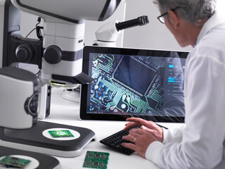 Engineer using a 3d stereo microscope for quality control in the manufacturing of circuit boards...
