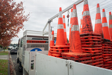Work truck loaded with Temporary signs and dirty orange traffic cones on the roadside. Roadworks in Auckland.