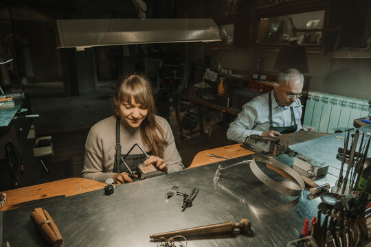 Artisan and his coworker making jewellery in his workshop - Powered by Adobe