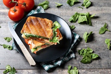 Healthy spinach, tomato and cheese sandwich on wooden table. Copy space