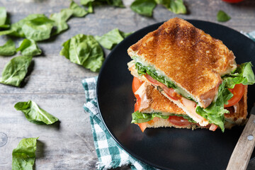 Healthy spinach, tomato and cheese sandwich on wooden table. Copy space