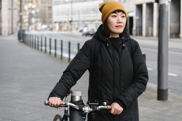 Woman with bicycle in the city, Frankfurt, Germany