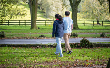 Couple holding hands and walking in autumn. Auckland.