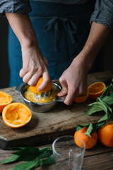 Young man's hands squeezing orange