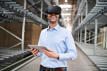 Businessman with tablet wearing VR glasses in factory