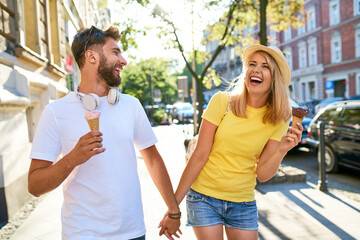 Happy young couple enjoying ice cream in the city