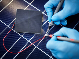 Technician measuring resistor of silicon solar cell