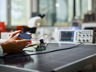 Technician holding silicon solar cell on solar panel