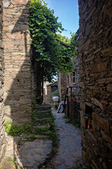 Beautiful medieval village Talasnal in Lousa, Portugal on a beautiful day. Child playing on the street of the village with his pet dog