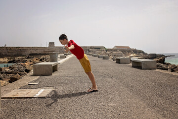 Cute child from european amily, visiting the most south point of Europe, Tarifa in Spain. Heavy...