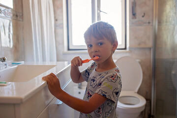 Cute child, brushing teeth in the bathroom in the morning