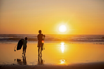 Happy children, boys, playing on the beach on sunset, kid cover in sand, smiling, laughing