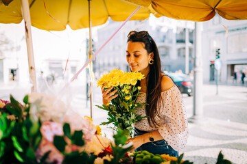 Young woman smelling bouquet of flowers at flower shop