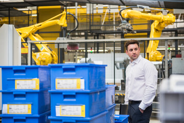 Businessman standing in factory shop floor
