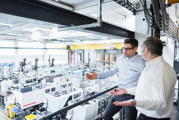 Two men talking in factory shop floor
