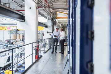 Two men talking in factory shop floor