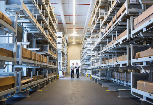 Two men standing in factory warehouse
