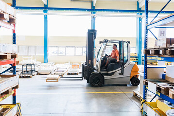 Man on forklift in factory warehouse