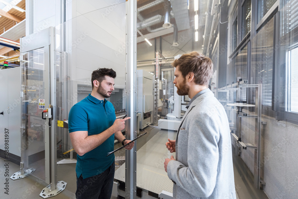 Sticker businessman and employee discussing in modern factory