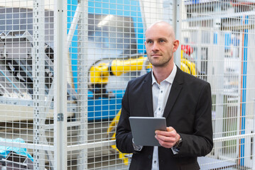 Businessman with tablet in modern factory