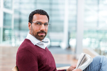 Businessman reading a newspaper in waiting hall