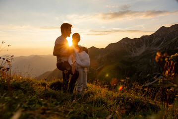 Germany, Bavaria, Oberstdorf, family with little daughter on a hike in the mountains at sunset