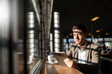 Businessman using tablet at the window in a cafe