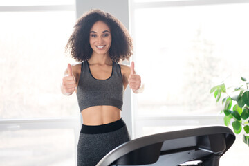 Photo of lovely cheerful girl trainer thumb up sport lesson gym daylight interior indoors