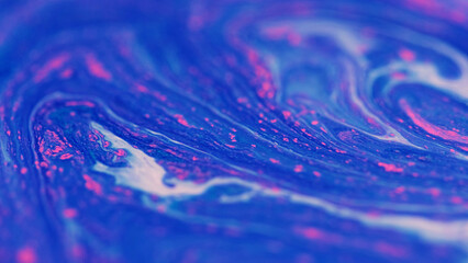 Glitter ink flow. Acrylic fluid. Defocused blue white pink color sparkling grain particles pigment...