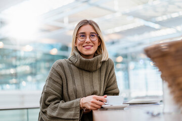 Portrait of a smiling young woman in a cafe