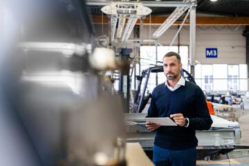 Businessman using tablet in a factory