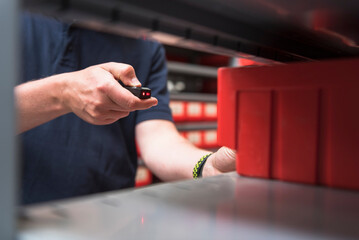 Close-up of man in storehouse of a factory using small scanner