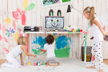 Three girls painting office with finger paint