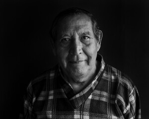 Smiling senior man against black background
