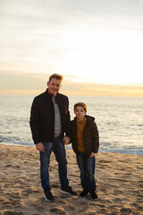 Portrait of father and son standing on the beach