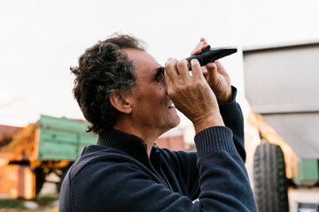 Man looking through refractometer at winery