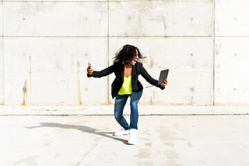 Woman holding smartphone and tablet, screaming and taking a selfie