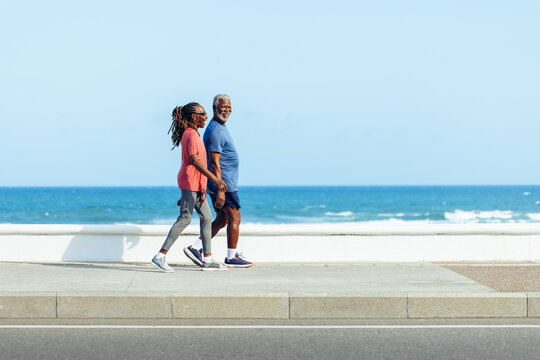 Older couple enjoying a sunny walk by the sea