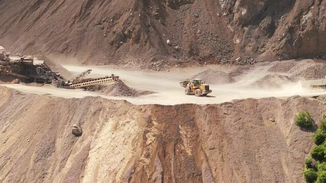 Detail view of a mining bulldozer dumping tailings into a cliff at a limestone mine in northern Argentina, Jujuy Province, lithium tringulum.