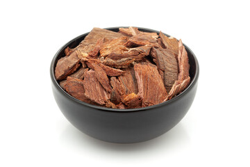 Close-up of Dry Organic Arjuna Barks (terminalia arjuna), in black ceramic bowl. Isolated on a white background.