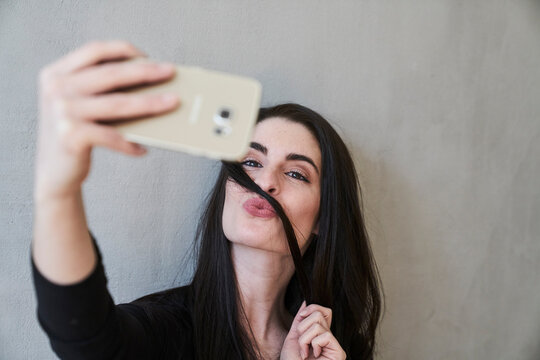 Young woman pouting taking a selfie - Powered by Adobe
