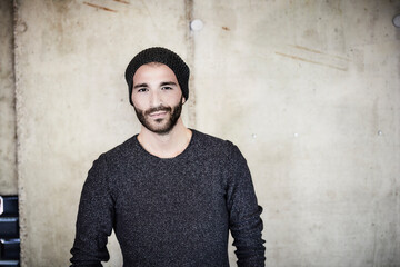 Portrait of confident young man at concrete wall