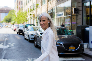 USA, Brooklyn, portrait of smiling mature woman crossing the street