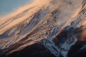 Scenic close-up of snow-covered trail and buildings on Mount Fuji in Fujikawaguchiko, Japan.