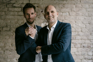 Portrait of confident mid-adult and senior businessman shaking hands