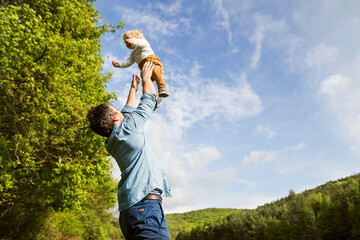 Father throwing baby in the air